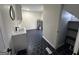 Laundry room with black hexagon tile, grey vanity, modern sink, contemporary mirror, and water heater at 22 Edgewood Dr, Carrollton, GA 30116