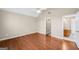 Inviting bedroom showcasing hardwood floors, neutral walls, and an open doorway to an ensuite bathroom at 238 Harvest Trce, Sharpsburg, GA 30277