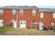 View of brick townhome exteriors featuring white doors and privacy fences plus a patio set at 6517 Snowbird Ln, Douglasville, GA 30134