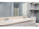 Bathroom showcasing double sinks, white cabinets, and shelving above the toilet at 6517 Snowbird Ln, Douglasville, GA 30134