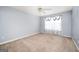 View of a carpeted bedroom with ceiling fan and sheer floral curtains at 6517 Snowbird Ln, Douglasville, GA 30134