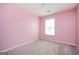 Bedroom with pink walls, neutral carpet, window, and ceiling light fixture at 6517 Snowbird Ln, Douglasville, GA 30134