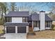 Two-story home featuring a gray roof, two car garage and a well manicured lawn at 1015 Chapman Ln, Stone Mountain, GA 30088