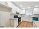 Modern kitchen featuring white cabinets, stainless steel appliances, granite countertops, and wood-style flooring at 1015 Chapman Ln, Stone Mountain, GA 30088