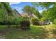 Lush backyard with mature trees, green grass, and a partially obscured deck at 9209 W Banks Mill Rd, Winston, GA 30187