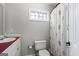 Small bath with a simple vanity, toilet, and a shower with a patterned curtain under a small window at 9209 W Banks Mill Rd, Winston, GA 30187