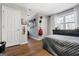 Bedroom with wood floors, large window, a gray comforter, and decor with a place for displaying awards at 9209 W Banks Mill Rd, Winston, GA 30187