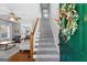 A welcoming entryway featuring a staircase, a floral wreath on the door, and a glimpse into the living area at 9209 W Banks Mill Rd, Winston, GA 30187