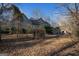 Exterior view of a home's backyard with bare trees and covered in leaves at 9209 W Banks Mill Rd, Winston, GA 30187