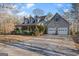 Traditional home with a large driveway, attached two-car garage, covered porch, and dormer windows at 9209 W Banks Mill Rd, Winston, GA 30187
