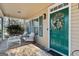 Cozy front porch with rocking chairs, a swing, and a vibrant green door adorned with a floral wreath at 9209 W Banks Mill Rd, Winston, GA 30187