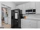 Modern kitchen features black refrigerator, white cabinets, and stainless steel appliances at 9209 W Banks Mill Rd, Winston, GA 30187