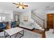 Open-concept living area with hardwood floors, stairs, ceiling fan, and neutral decor at 9209 W Banks Mill Rd, Winston, GA 30187