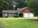Home featuring a two-car garage, wood, and stone elements at 9091 Woodgreen Way, Jonesboro, GA 30238