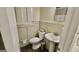 Bathroom features a pedestal sink, toilet, window with shutters, decorative mirror and patterned tile flooring at 365 Jordan Dr, Tucker, GA 30084