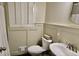 Bathroom features a toilet, pedestal sink, window with shutters, and patterned tile flooring at 365 Jordan Dr, Tucker, GA 30084