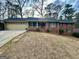 Brick home with a cozy front porch and a well-manicured front yard and attached garage at 365 Jordan Dr, Tucker, GA 30084