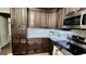 Close-up of kitchen with stainless steel microwave, dark wood cabinets and mosaic tile backsplash at 365 Jordan Dr, Tucker, GA 30084