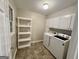 Convenient laundry room with washer, dryer, shelving, and storage cabinets at 365 Jordan Dr, Tucker, GA 30084