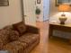 Living room with a floral patterned couch and desk, complemented by hardwood flooring at 4019 Pin Oak Trl, Decatur, GA 30034