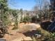 Large backyard with a privacy fence, landscaping, and multi-level wooden retaining wall at 718 Avalon Way, Peachtree City, GA 30269