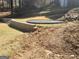 Backyard with retaining wall and a gravel section ready for trampoline or play area at 718 Avalon Way, Peachtree City, GA 30269