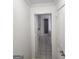 Bathroom hallway featuring tile flooring, neutral walls, and a partial view of a bathroom with a shower at 718 Avalon Way, Peachtree City, GA 30269