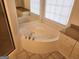 Bathroom with granite counters, tile flooring, and a corner soaking tub with windows and white cabinetry at 718 Avalon Way, Peachtree City, GA 30269