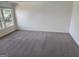 Bright bedroom showcasing neutral paint, carpet flooring, and a large window offering exterior views at 718 Avalon Way, Peachtree City, GA 30269
