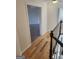 Bright hallway with wood floors leading to a doorway and stairs with white balusters at 718 Avalon Way, Peachtree City, GA 30269