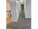 Hallway featuring carpet flooring, white walls and doors, and glimpses of hardwood stairs and a tiled bathroom at 718 Avalon Way, Peachtree City, GA 30269
