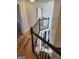 Hallway with wood floors leading to the stairs with dark wood and white balusters at 718 Avalon Way, Peachtree City, GA 30269