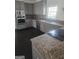 Modern kitchen with stainless steel appliances, gray cabinets, and granite countertops at 718 Avalon Way, Peachtree City, GA 30269
