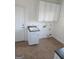 Bright laundry room with white cabinets, tile flooring, and a utility sink at 718 Avalon Way, Peachtree City, GA 30269