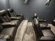 Home theater features multiple reclining seats, projector screen, and carpet for entertainment at 718 Avalon Way, Peachtree City, GA 30269