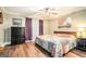 Inviting bedroom featuring a wood bedframe, colorful quilt, and hardwood floors at 1083 Hampton Rd, Hampton, GA 30228
