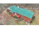 Aerial view of a brick home showcasing a green roof, and a red deck at 81 Bowers Rd, Moreland, GA 30259