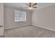 Neutral bedroom featuring plush carpeting, ceiling fan and natural light from a bright window at 81 Bowers Rd, Moreland, GA 30259
