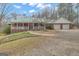 Charming brick home with a sprawling porch, complemented by a well-manicured lawn and a two car garage at 81 Bowers Rd, Moreland, GA 30259