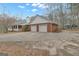 Side view of a brick home featuring a spacious two-car garage and an expansive driveway at 81 Bowers Rd, Moreland, GA 30259
