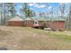 Back of a brick home with a green metal roof, a stained deck, and an above-ground propane tank at 81 Bowers Rd, Moreland, GA 30259