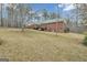View of a red brick house with green metal roof and a small stained wooden deck at 81 Bowers Rd, Moreland, GA 30259