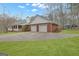 Rear view of red brick house with two car garage, green metal roof, and a spacious well-manicured backyard at 81 Bowers Rd, Moreland, GA 30259