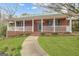 Charming brick home featuring a covered front porch with white railing and a walkway to the front door at 81 Bowers Rd, Moreland, GA 30259