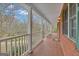 Expansive covered porch showcasing white columns, terracotta tile flooring, and green shutters on a brick exterior at 81 Bowers Rd, Moreland, GA 30259