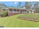 Charming brick home with a metal roof, white porch railing, and well-manicured lawn with garden bed at 81 Bowers Rd, Moreland, GA 30259