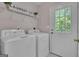 Laundry room with white appliances, decorative wall art, and an exterior door to the yard at 81 Bowers Rd, Moreland, GA 30259