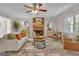 Cozy living room with brick fireplace, ceiling fan, stylish furniture, and decor accents at 81 Bowers Rd, Moreland, GA 30259