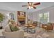 A sun-drenched living room showcases a brick fireplace, plush seating, and natural light from large windows at 81 Bowers Rd, Moreland, GA 30259