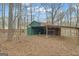 Exterior view of a green outbuilding with an open wood storage shed attached at 81 Bowers Rd, Moreland, GA 30259